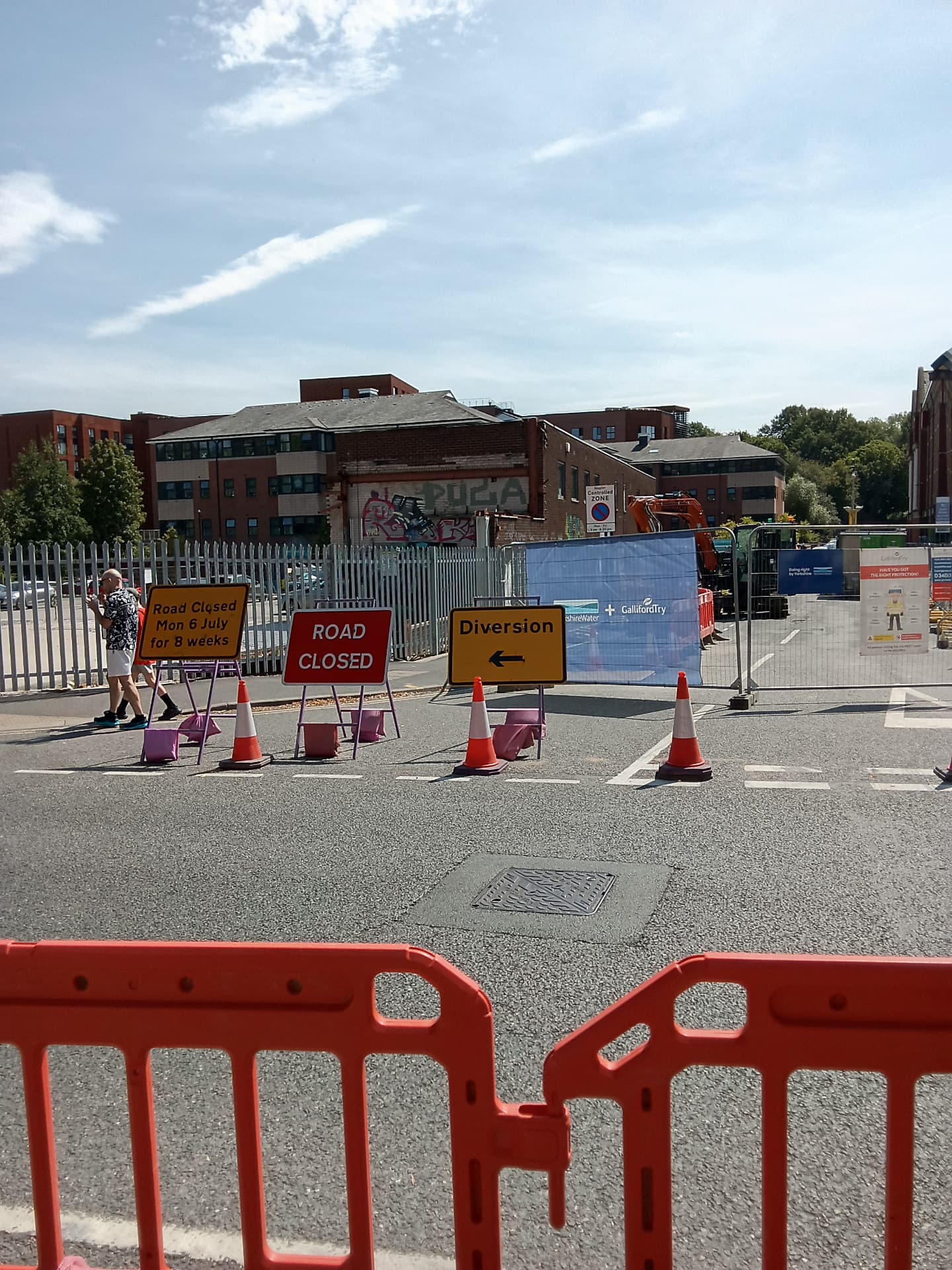 Road closed and diversion signage protecting a utilities excavation
